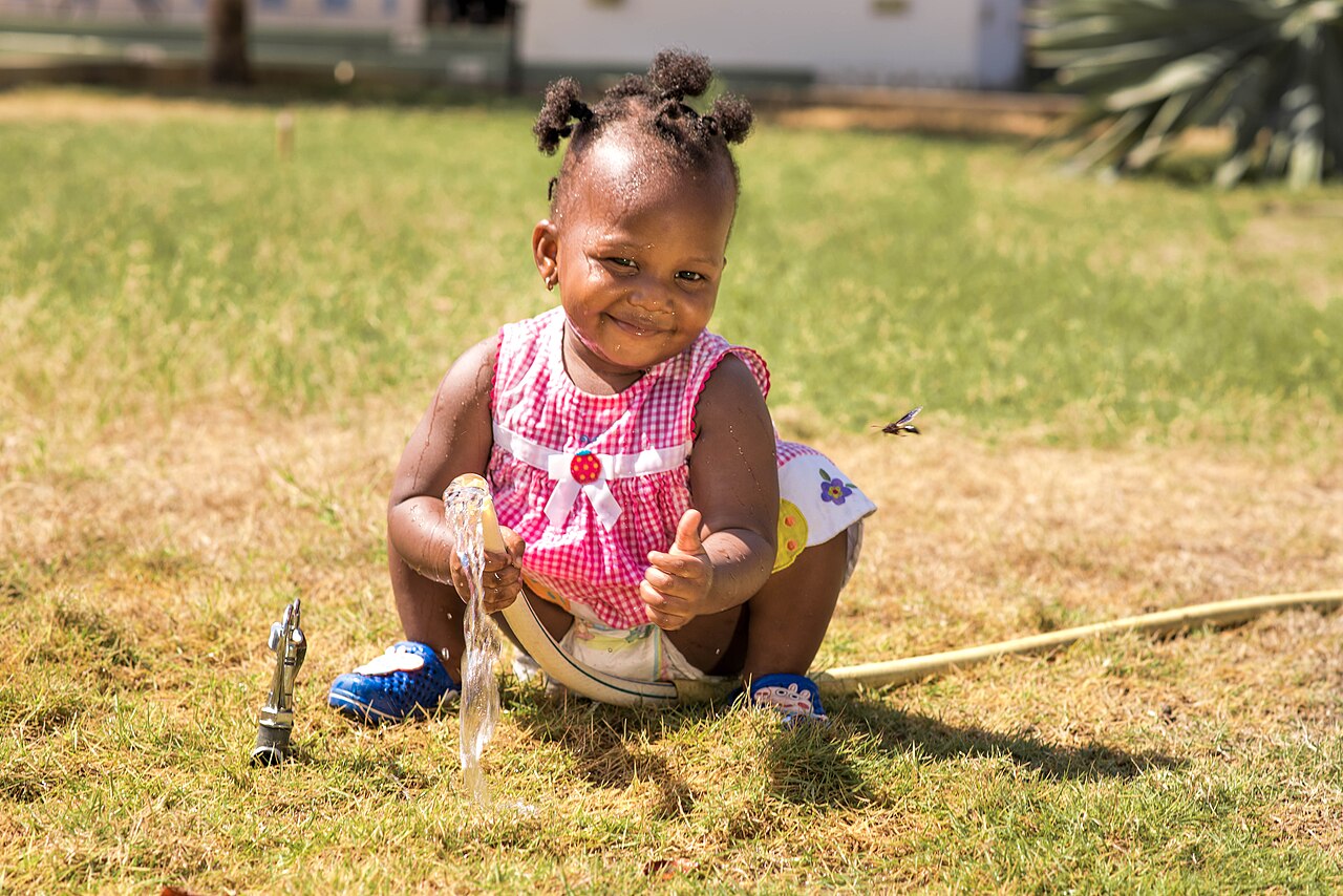 Child playing with water on a hot summer day