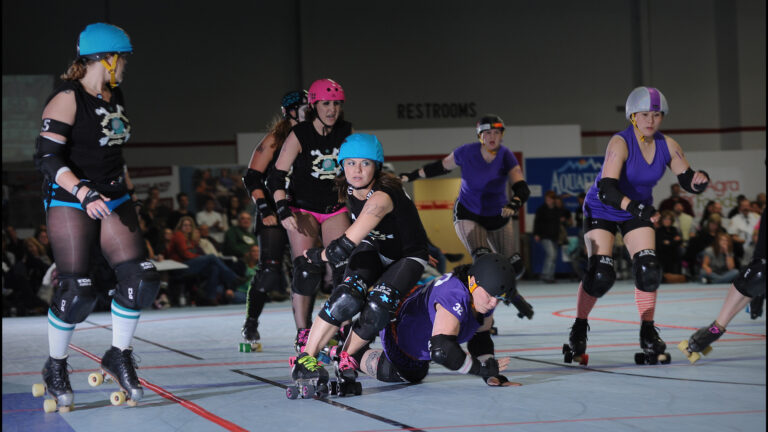 Roller derby jammer skating past blockers in intense bout action