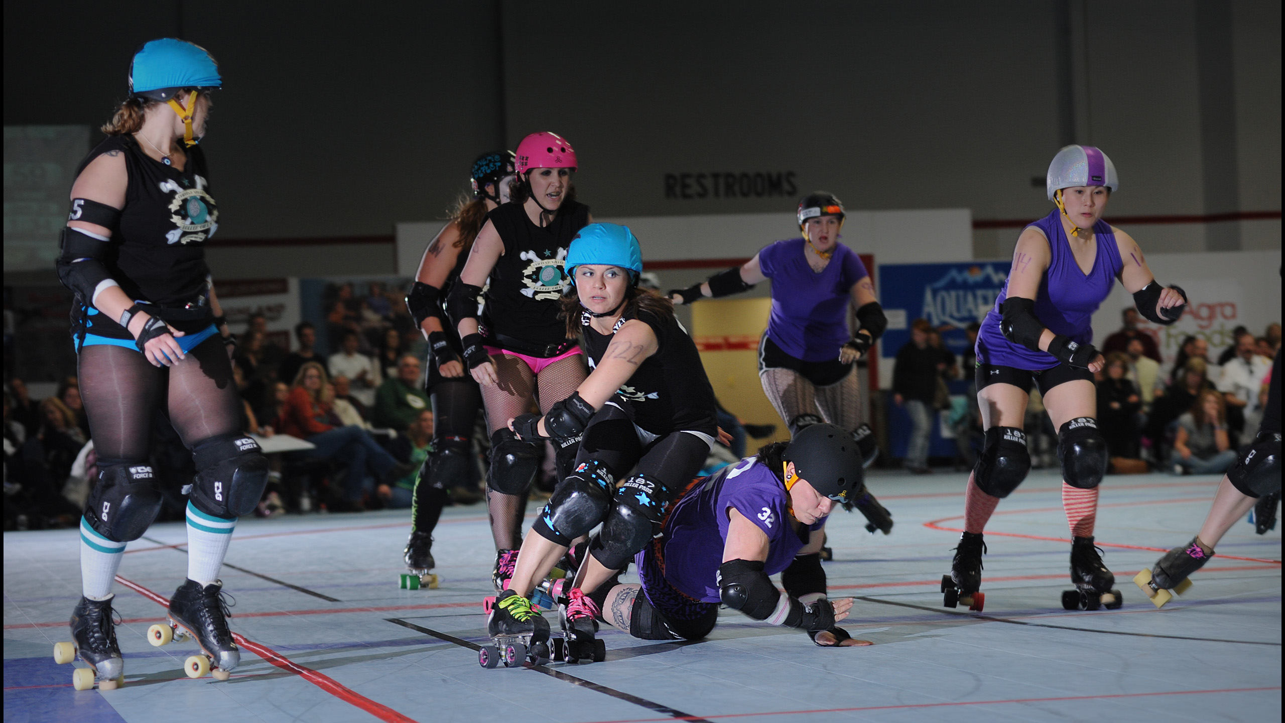 Roller derby jammer skating past blockers in intense bout action