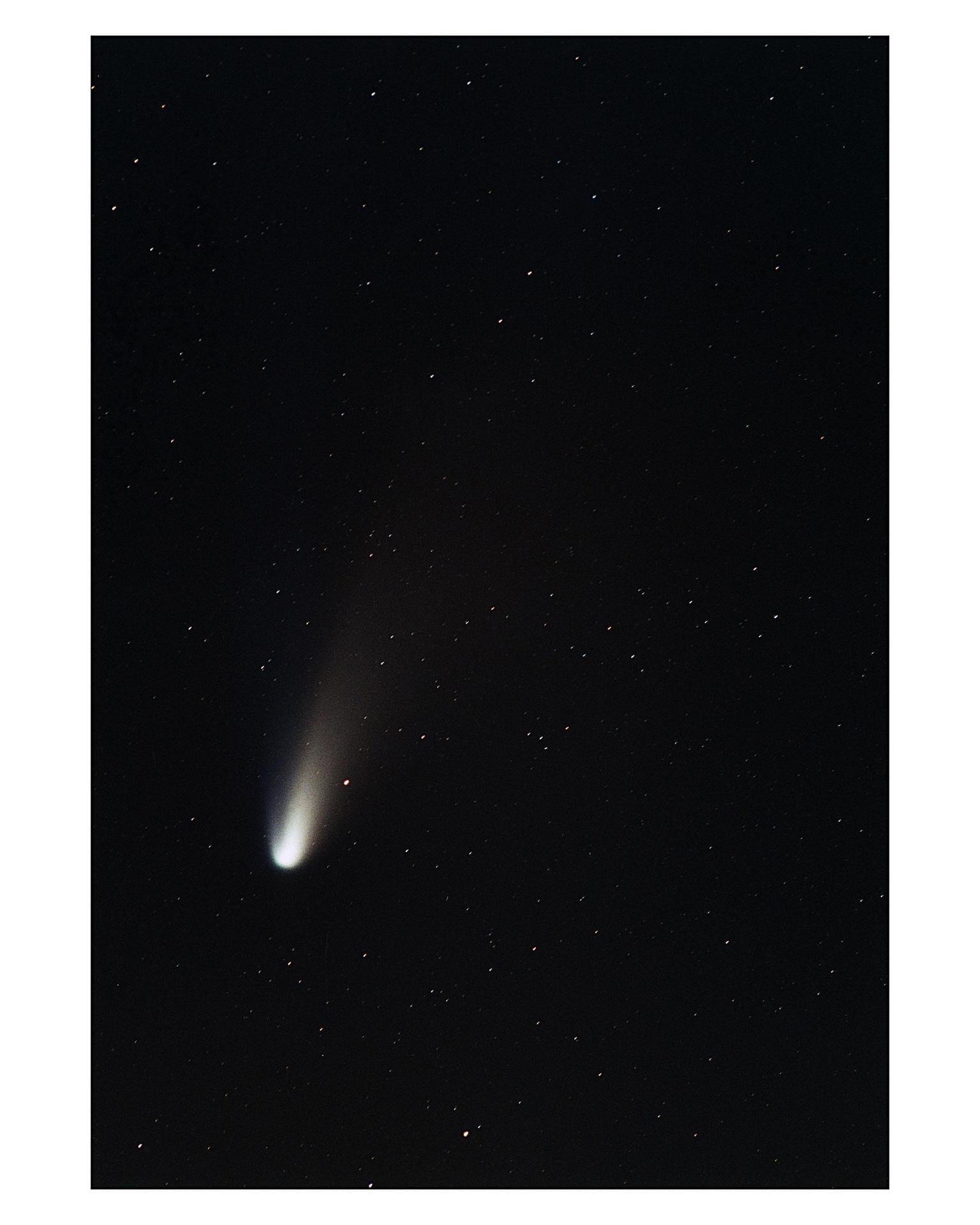 Hale-Bopp comet photographed at Kennedy Space Center during 1997 showing bright nucleus and tail over NASA launch facilities representing intersection of space exploration and popular UFO beliefs