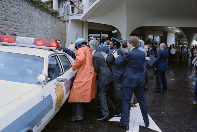 Secret Service agents crowd around John Hinckley Jr after he shot President Reagan outside Washington Hilton 1981