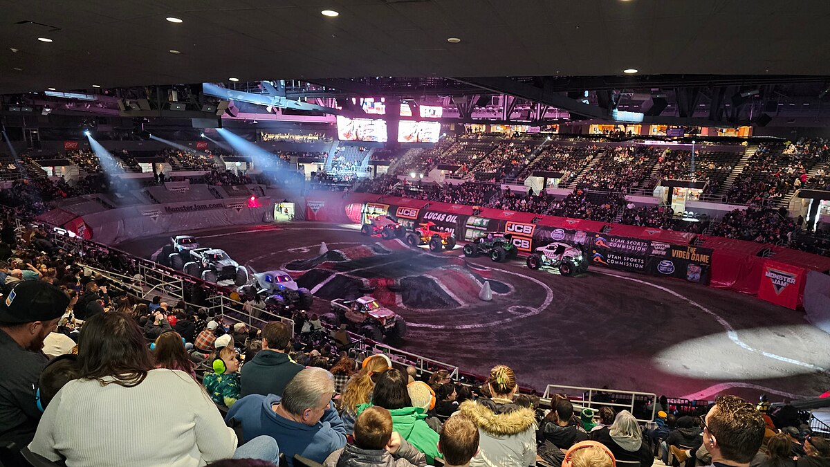 Monster Jam arena event with monster trucks and packed crowd