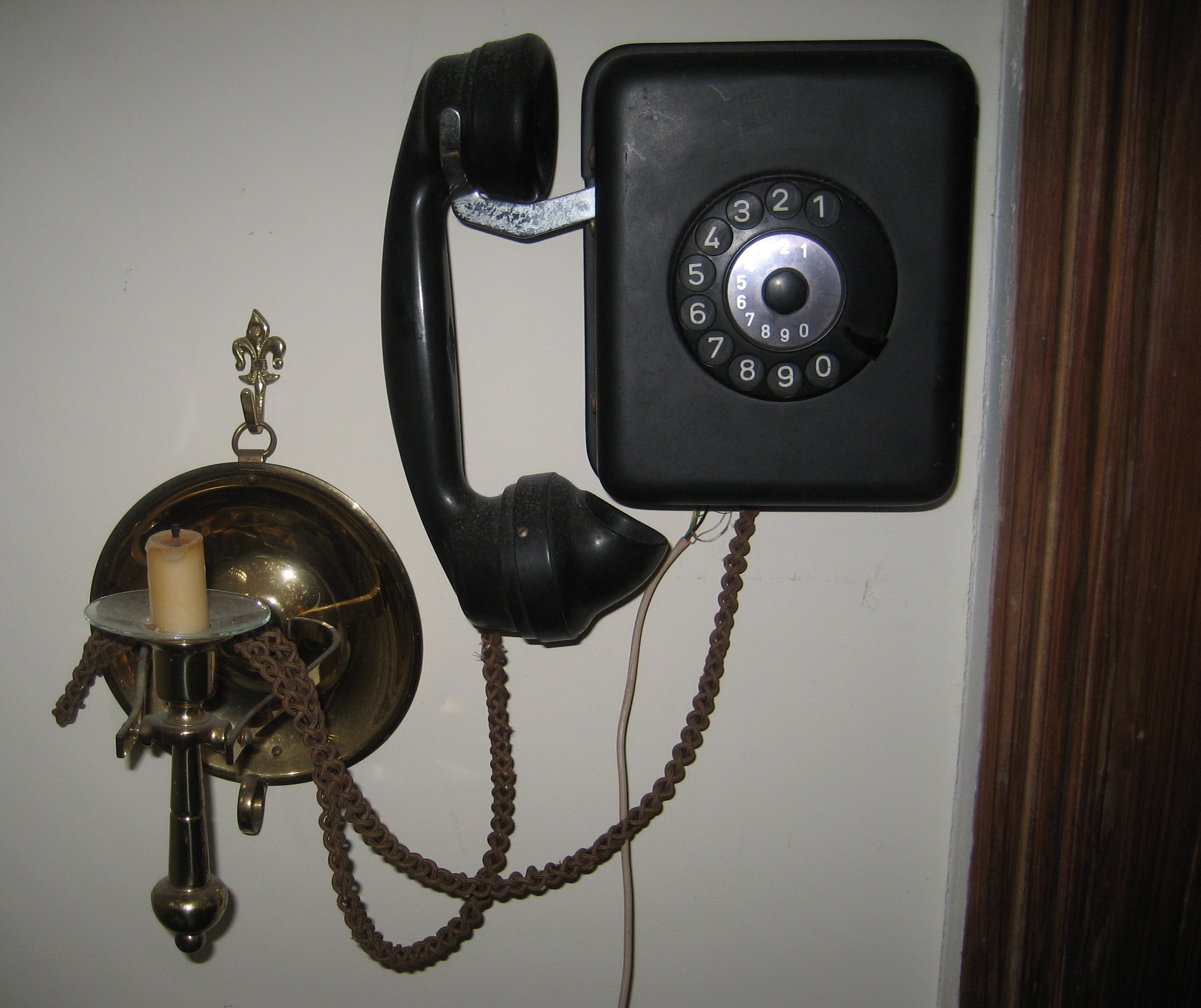 Vintage rotary dial wall phone with curly cord in American home