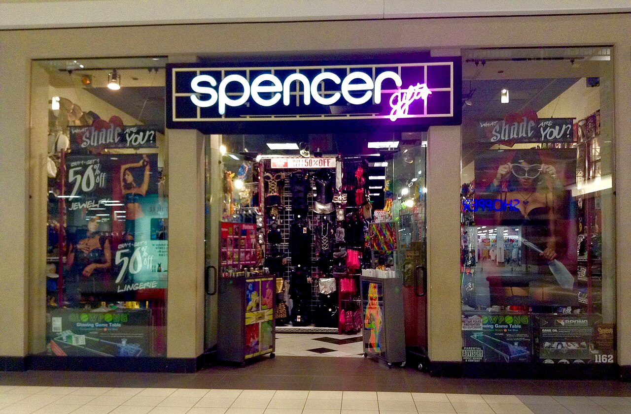 Spencer Gifts storefront in an American shopping mall with novelty items visible