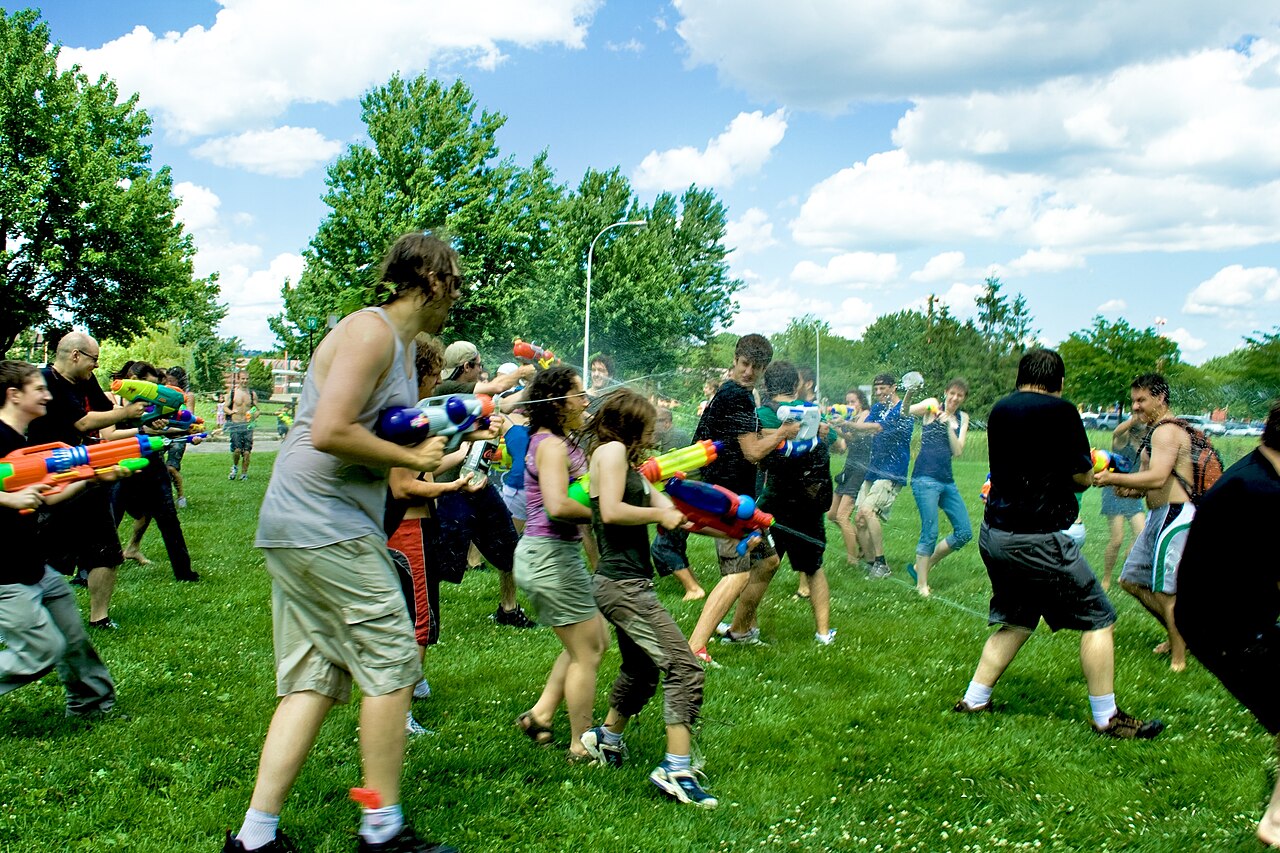 Summer water fight battle with hoses and water guns