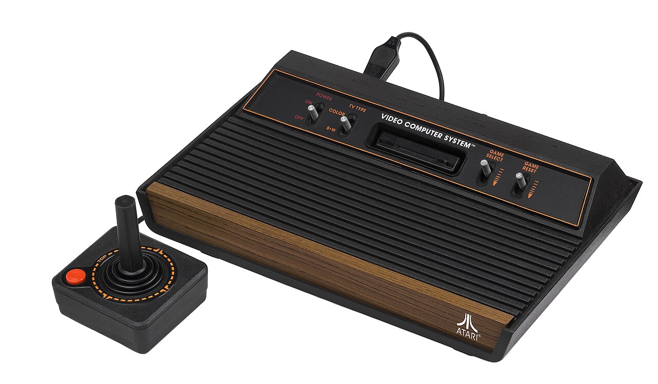 Atari 2600 with wood paneling and joystick — the original home gaming console of the early 80s