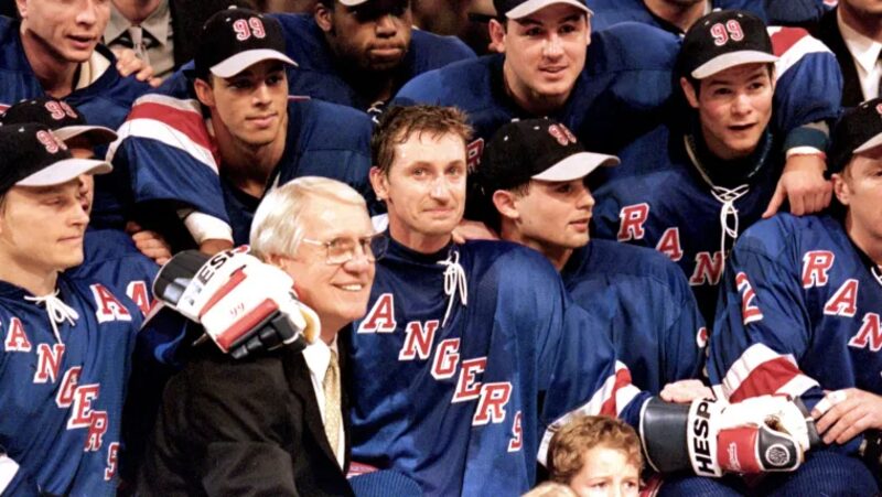 Wayne Gretzky poses with Rangers teammates and staff wearing commemorative 99 caps during farewell celebration
