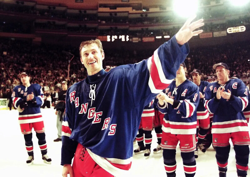 Wayne Gretzky raises his arms in appreciation as Rangers teammates applaud during his retirement ceremony