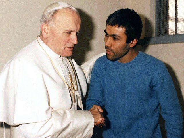 Pope John Paul II shakes hands with Mehmet Ali Agca during their 1983 prison meeting