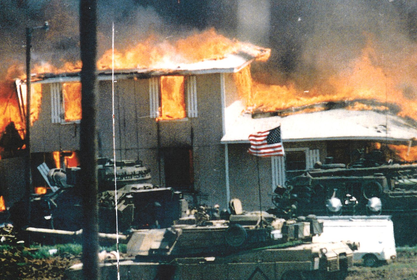Branch Davidian compound burning with military tanks outside during the Waco siege final day April 19 1993