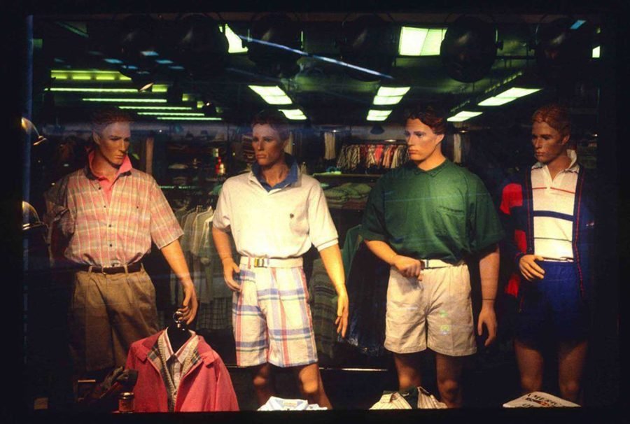 1980s mall mens fashion store window display with mannequins in pastel polos and plaid shorts