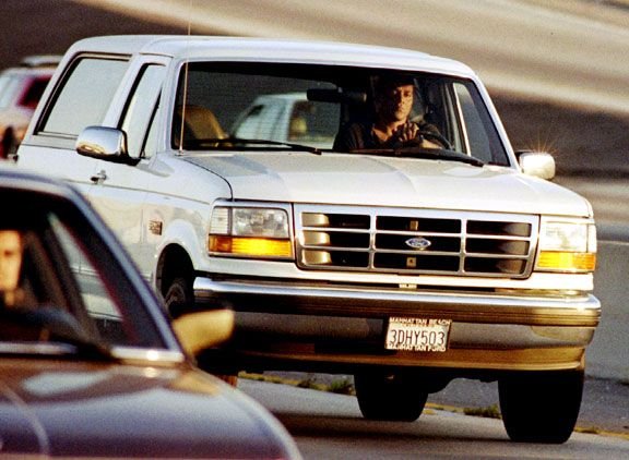 Al Cowlings driving the white Ford Bronco while OJ Simpson hides in the back seat with a gun
