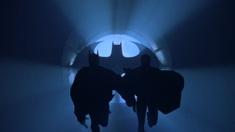 Batman and Robin run toward the Bat-Signal in the Batcave during Batman Forever 1995