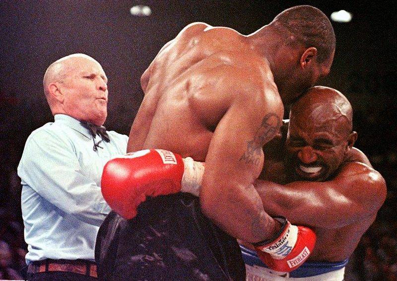 Evander Holyfield reacts in pain as Mike Tyson bites his ear in round three of the bite fight