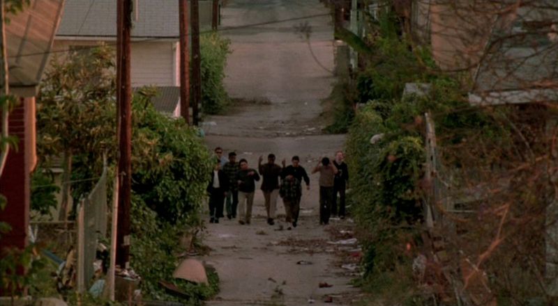 Suspects walking down alley at gunpoint during the hilltop raid finale — Colors 1988