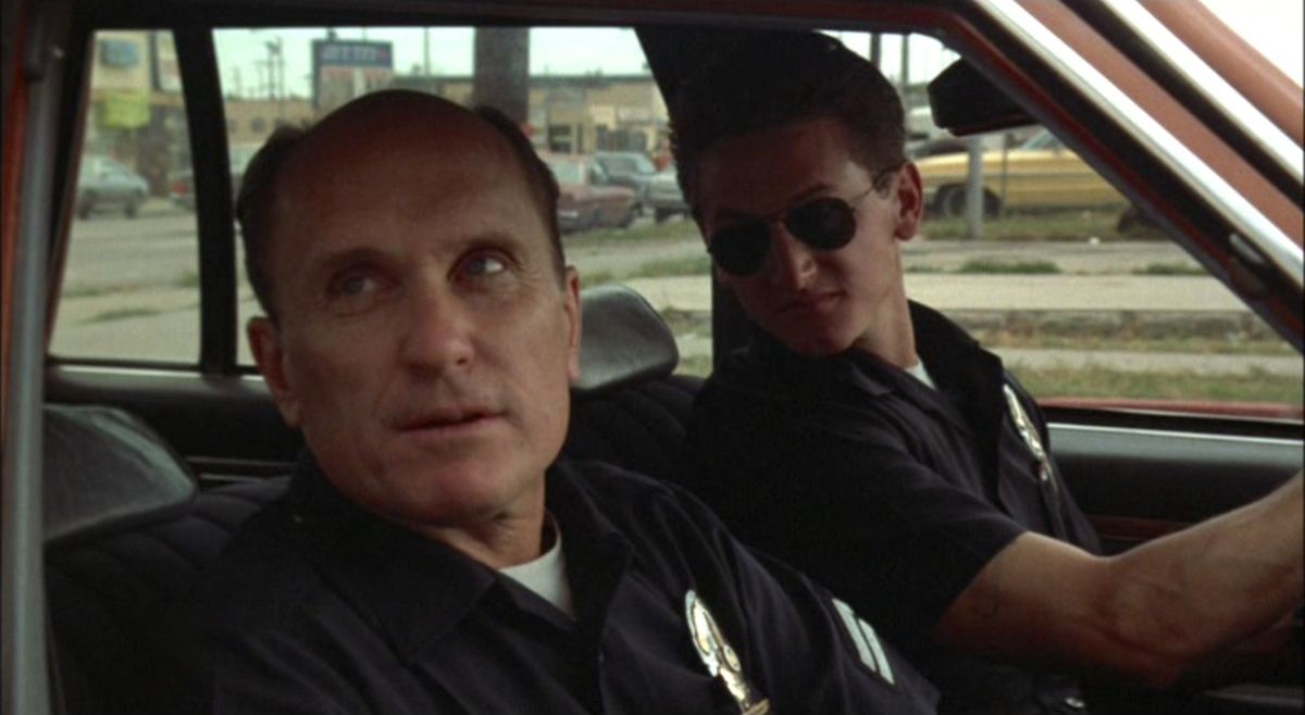 Robert Duvall and Sean Penn riding in a patrol car in Colors 1988 movie still