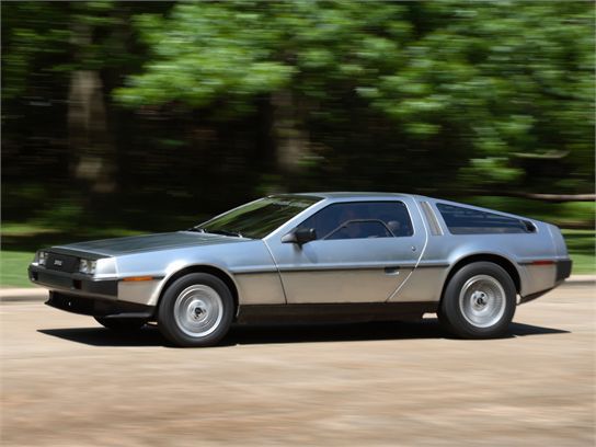 DeLorean DMC-12 stainless steel sports car driving side profile road