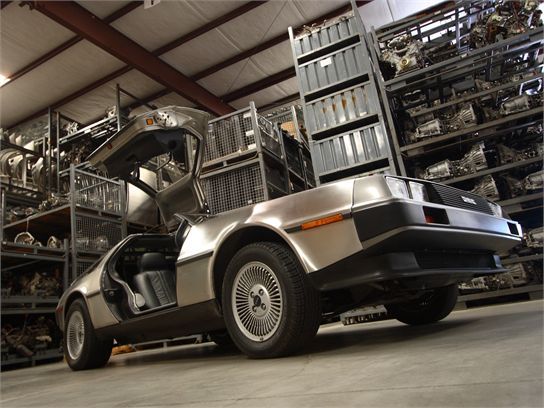 DeLorean DMC-12 rear three quarter view gullwing door open warehouse