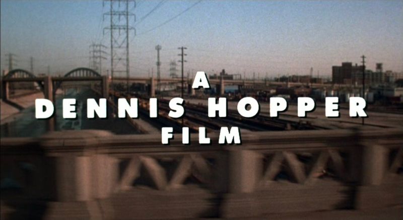 A Dennis Hopper Film opening title card over LA railyard — Colors 1988 movie