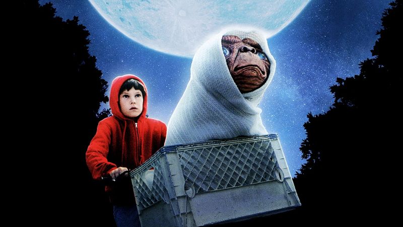 Elliott in red hoodie with E.T. in bike basket