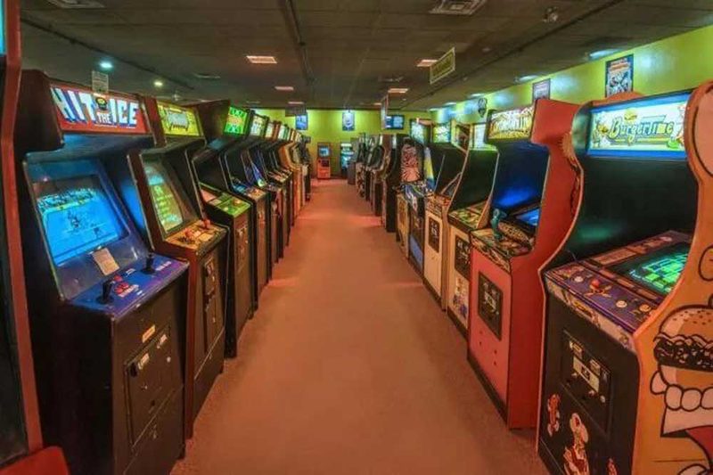 Empty 1980s arcade floor with two rows of cabinets at closing time