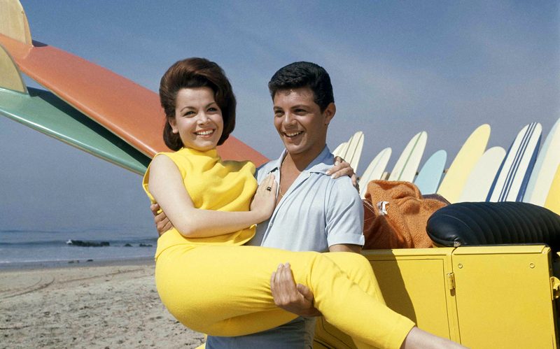 Frankie Avalon and Annette Funicello posing with surfboards in a beach party movie