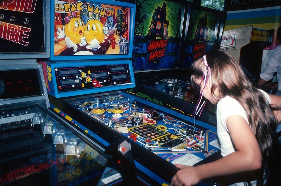 Girl playing Mr and Mrs Pac-Man pinball machine at a Times Square arcade 1982