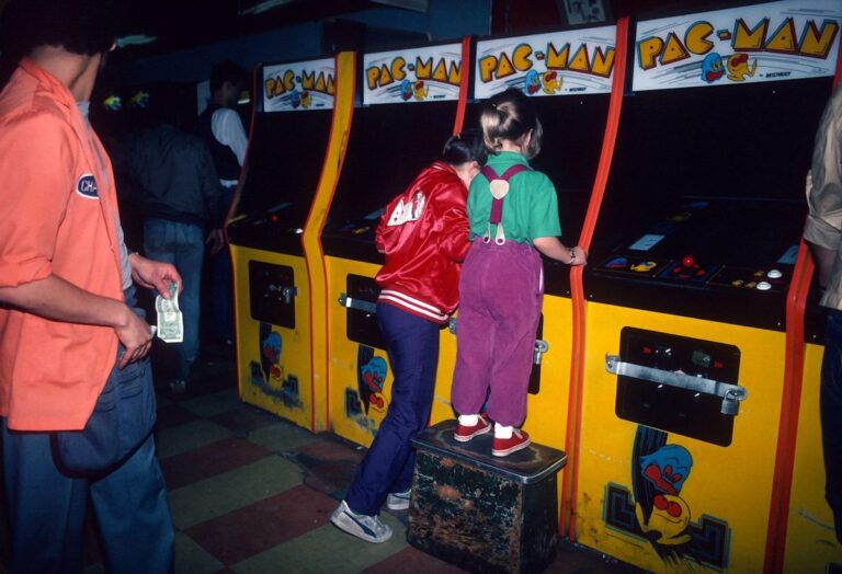 Girls playing Pac-Man arcade cabinets at Times Square New York 1982