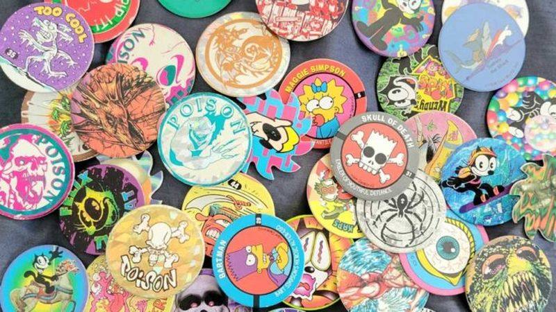 Pogs 90s craze mixed design collection including Simpsons skulls and poison