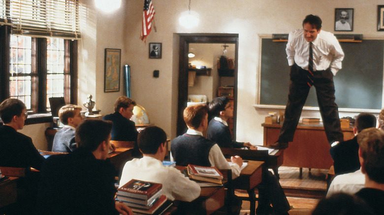 Robin Williams as John Keating standing on the desk in Dead Poets Society