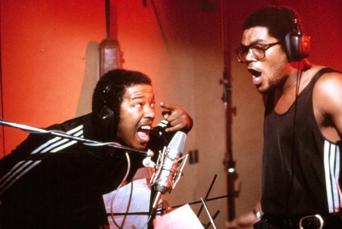 Run-DMC rapping in the studio wearing Adidas tracksuits during 90s hip-hop golden era
