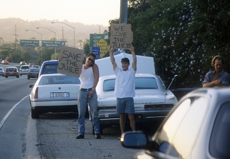 Fans holding Save The Juice and We Love The Juice cardboard signs along the 405 freeway during the OJ Simpson chase