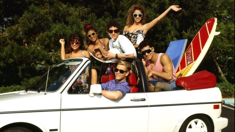 Saved by the Bell cast posing in the iconic white convertible with a surfboard
