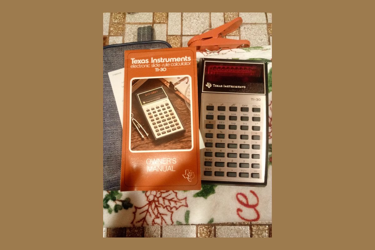 Texas Instruments TI-30 scientific calculator from 1976 with red LED display and original owners manual