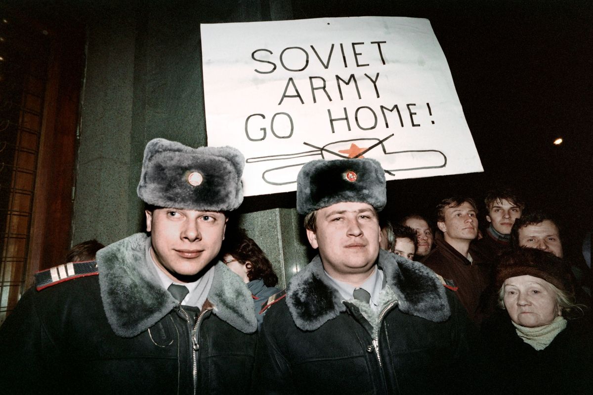 Lithuanian civilians hold a Soviet Army Go Home sign behind two Soviet officers during the January 1991 Vilnius standoff