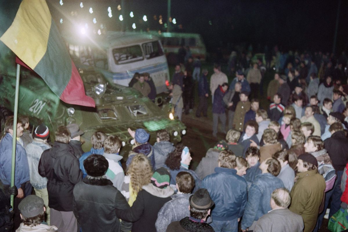 Lithuanian crowd surrounds a Soviet armored vehicle while holding the Lithuanian flag during the January 1991 Vilnius crackdown