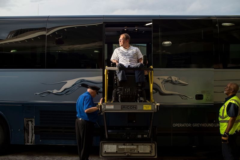 John Morris exits a bus using a wheelchair lift required by the 1990 Americans with Disabilities Act