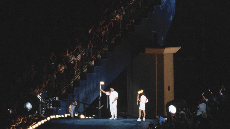 Muhammad Ali raises the Olympic torch on the ramp as Janet Evans watches, Atlanta 1996