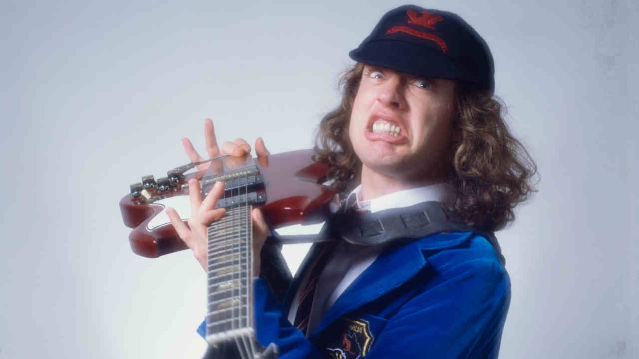 Angus Young in his trademark AC/DC schoolboy uniform with his SG guitar