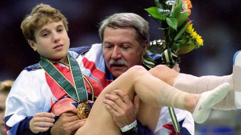 Coach Bela Karolyi carrying Kerri Strug with gold medal at the 1996 Atlanta Olympics medal ceremony