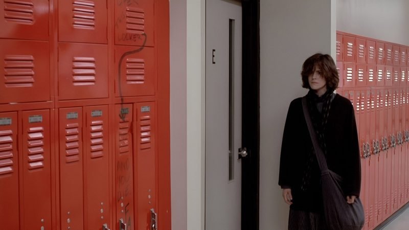 Ally Sheedy as Allison Reynolds standing at red school lockers in The Breakfast Club