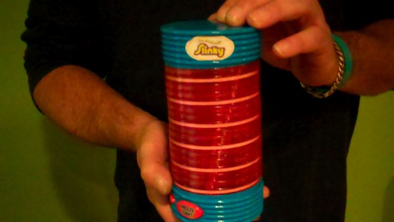 Colorful red and blue plastic Slinky toy held in both hands
