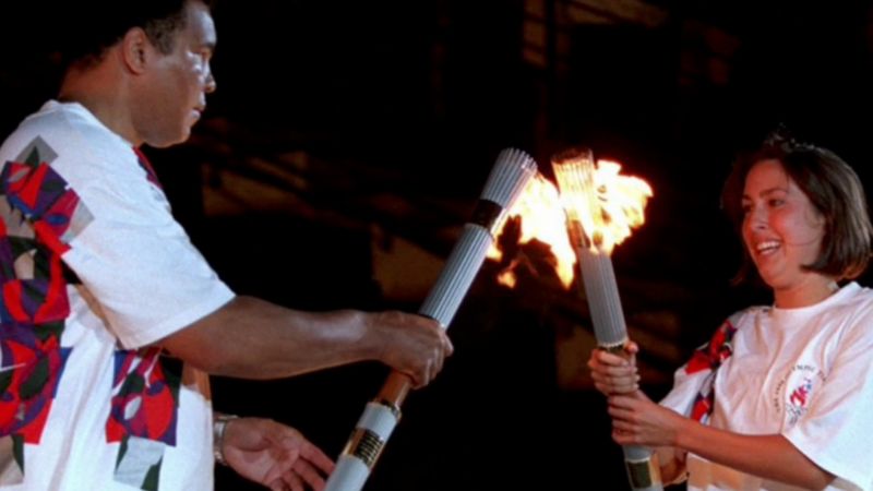 Swimmer Janet Evans passes the Olympic flame to Muhammad Ali at Atlanta 1996