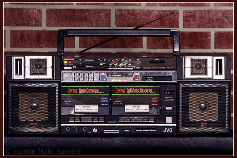 Large black JVC PC-W330 boombox with dual cassette decks against a brick wall