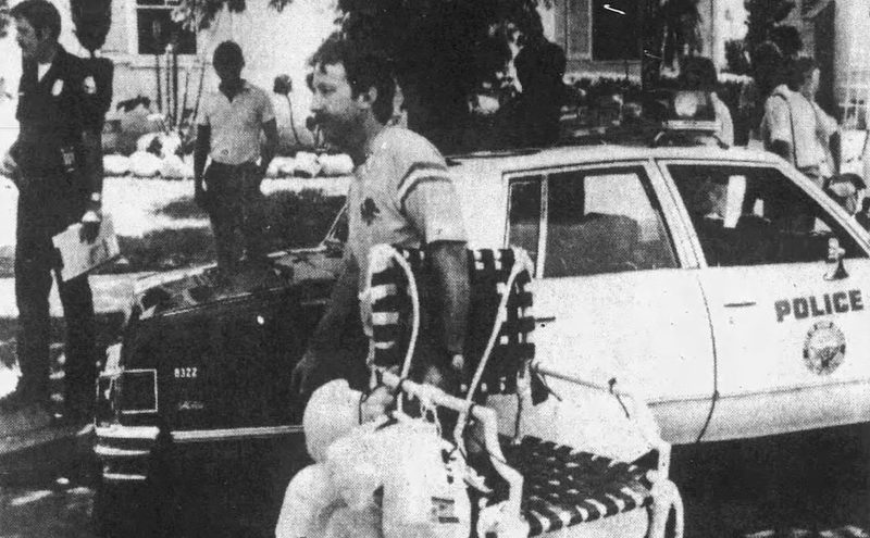 Larry Walters carrying his balloon lawn chair past a Long Beach police car after landing