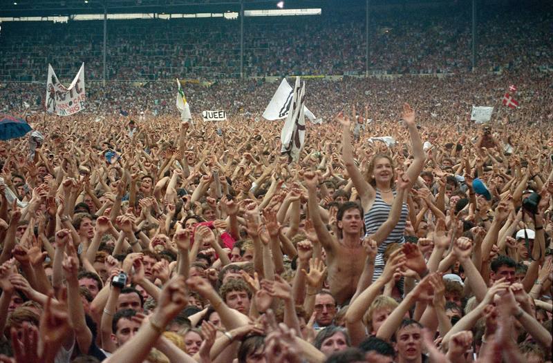 Live Aid audience cheering with a Queen banner at Wembley 1985
