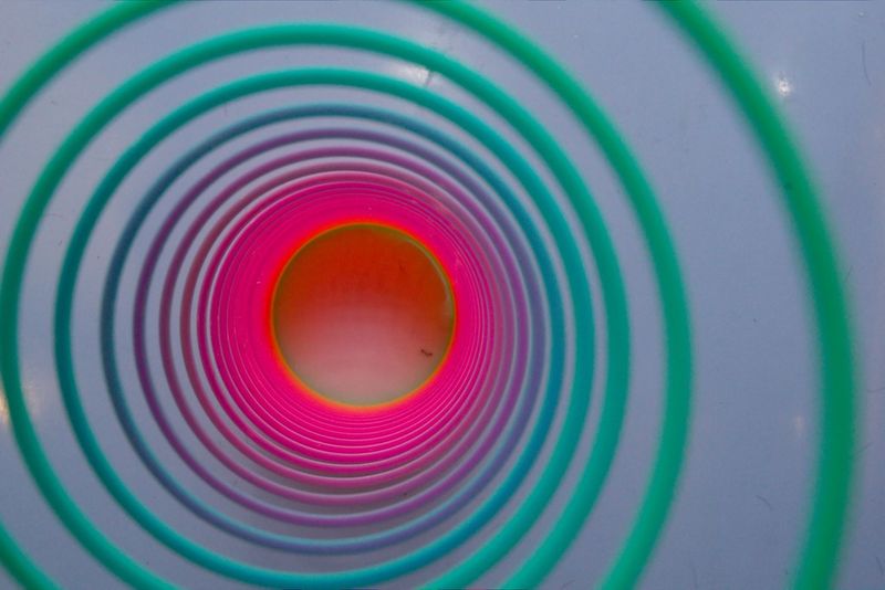 Rainbow plastic Slinky toy showing colorful concentric coils