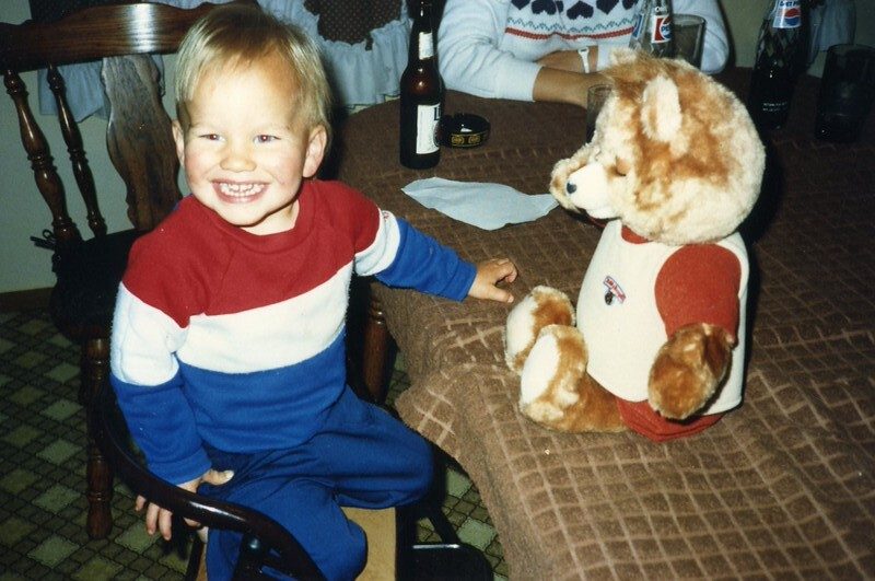 A vintage 1980s photo of a toddler with his Teddy Ruxpin bear