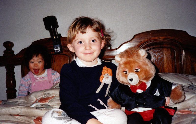A child in the 1980s with a Teddy Ruxpin talking bear in a tuxedo