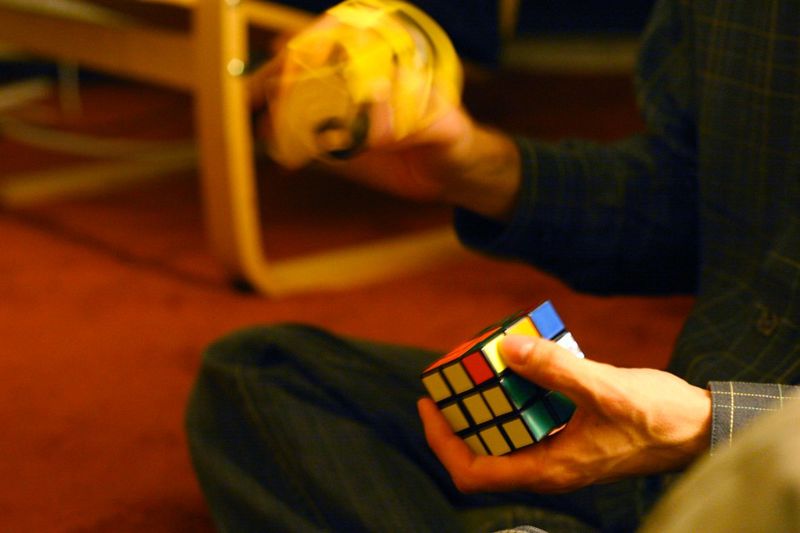 A person solving a Rubik's Cube while sitting on the floor
